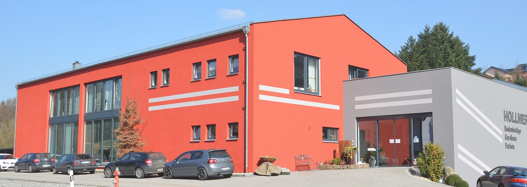 Das Firmengebäude von Hollmer Raumausstattung in Stallwang mit Parkplatz